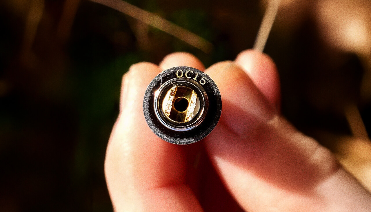Close-up of a person holding an OC15 electronic connector in hand, showcasing details and gold contacts.
