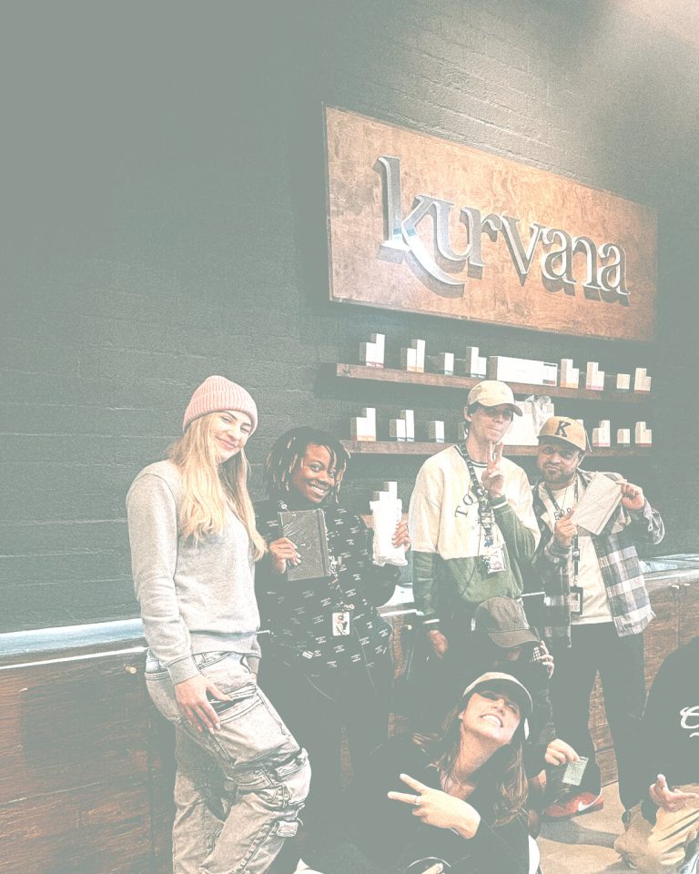 kurvana-events-near-me-california | Kurvana | Curated for years. Experienced in moments. Group posing in front of Kurvana sign with products, casual attire, and smiles.